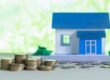 model house with coins wooden table